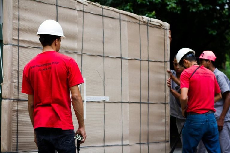 Equipe transportando vidro embalado para içamento